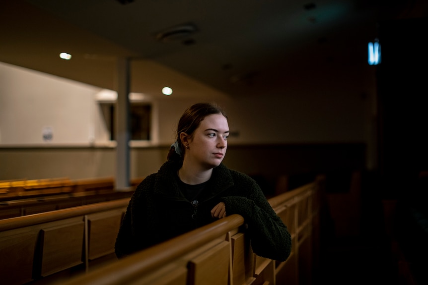 Emily Harrison sits on a bench inside a synagogue.