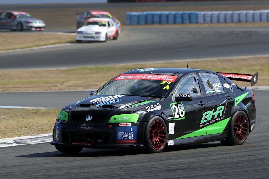 A black racing car drives on a winding track