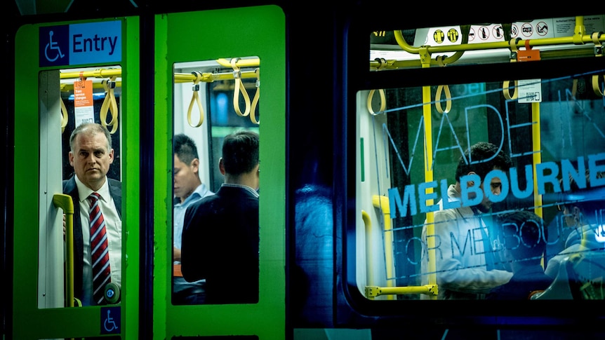 A man looking out a window on a tram in Melbourne