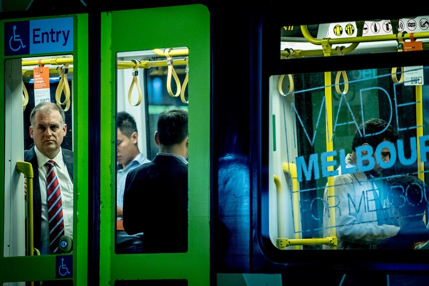 A man looking out a window on a tram in Melbourne