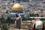 A Palestinian man stands at a lookout on the Mount of Olives