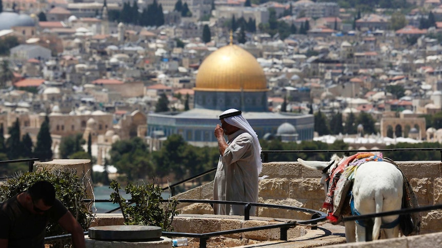 A Palestinian man stands at a lookout on the Mount of Olives