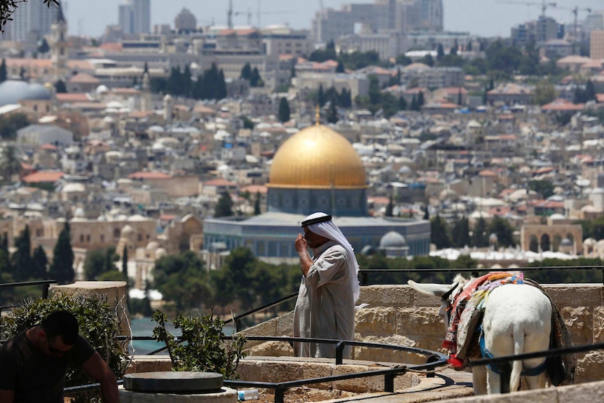 A Palestinian man stands at a lookout on the Mount of Olives