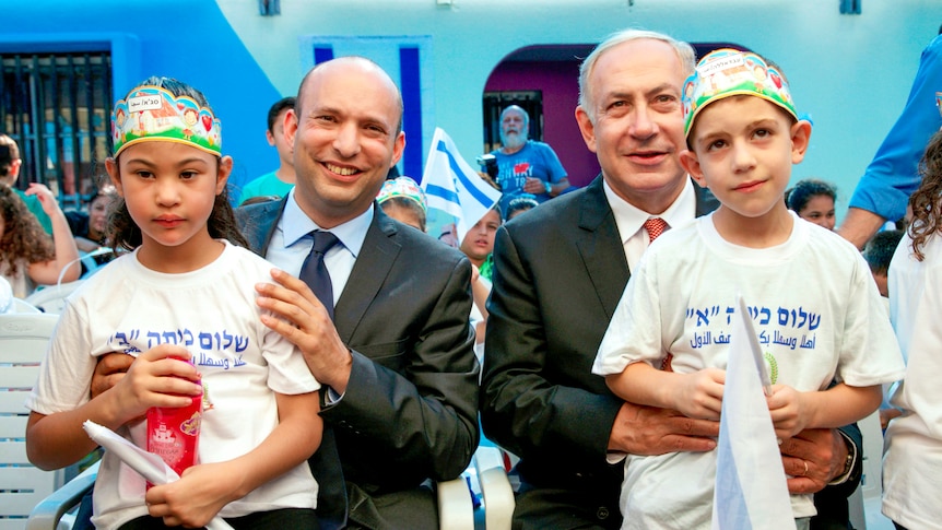 Benjamin Netanyahu 和 Naftali Bennett 与跪着的孩子们坐在一起 