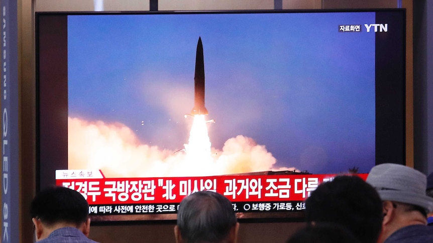 People in South Korea watch a large TV broadcasting a North Korean missile launch.
