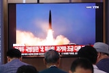 People in South Korea watch a large TV broadcasting a North Korean missile launch.