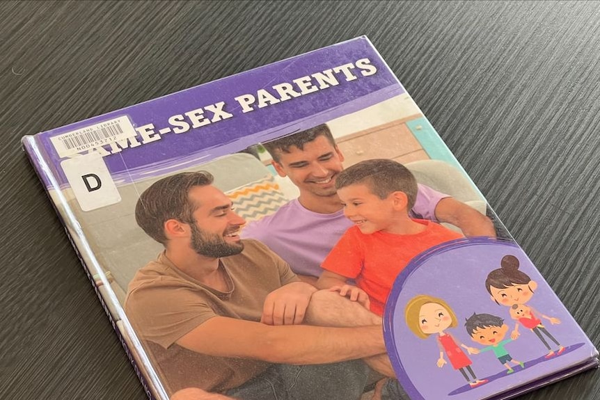 Picture of the book called "Same Sex parents". Two men with a boy all smiling. 