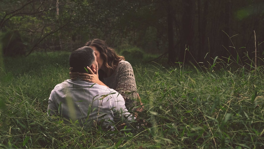 Couple kissing in long grass pictured in story about eco-friendly sex