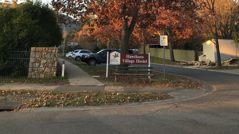 A sign at the end of a driveway 'Hawthorn Village Hostel'.