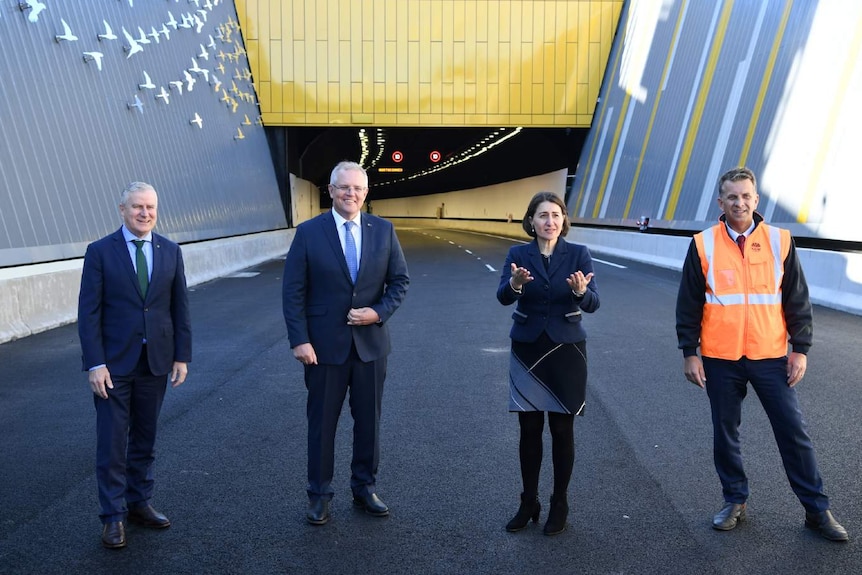 Four people outside a tunnel