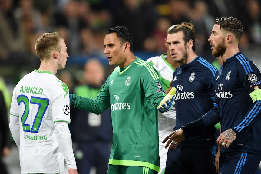 Real Madrid players confront Wolfsburg's Maximilian Arnold