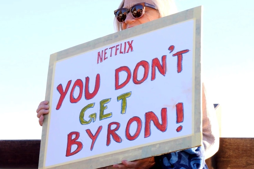 A woman holds a sign saying Netflix you don't get Byron
