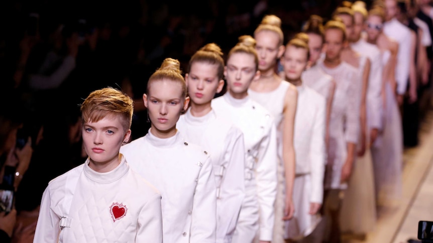 Models in white walk the runway in France