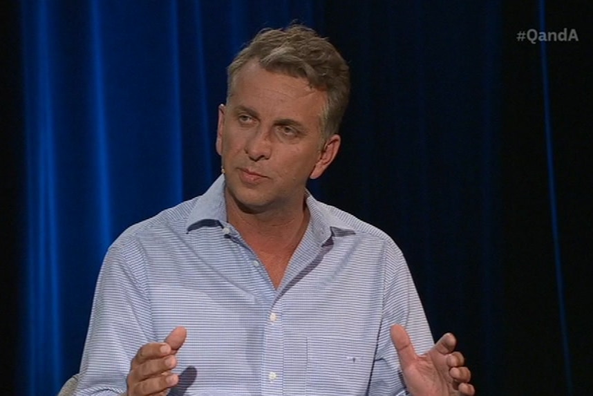 a man speaking on a panel