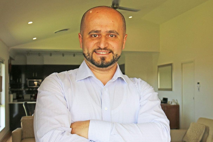 Anas Barbaree stands smiling with his arms crossed at his house in Kalinga in Brisbane in October 2019.