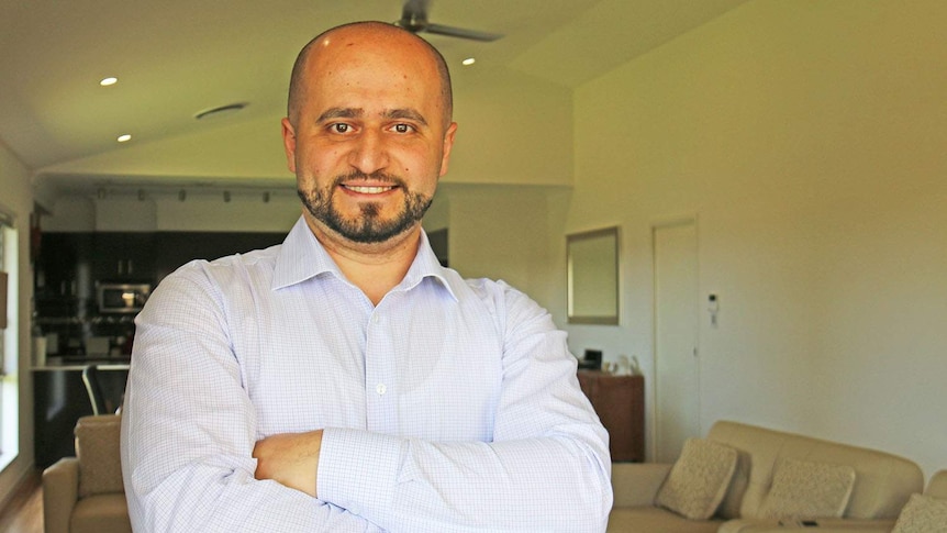 Anas Barbaree stands smiling with his arms crossed at his house in Kalinga in Brisbane in October 2019.