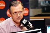 Chief Minister Michael Gunner in the ABC Radio Darwin studio. He is wearing a red and blue checked shirt.