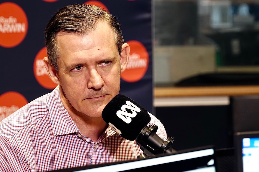 Chief Minister Michael Gunner in the ABC Radio Darwin studio. He is wearing a red and blue checked shirt.