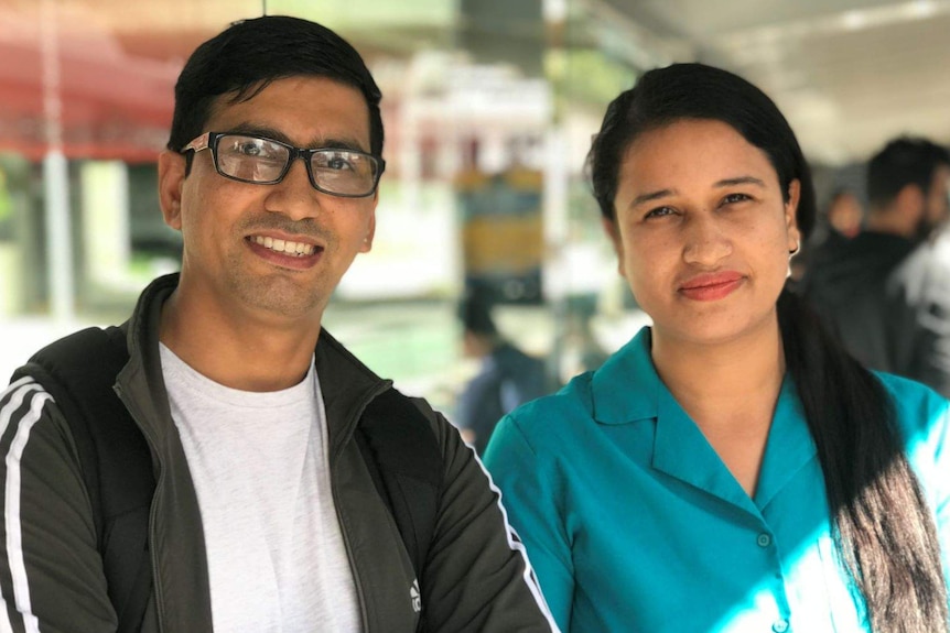 A couple smiling at a bus station