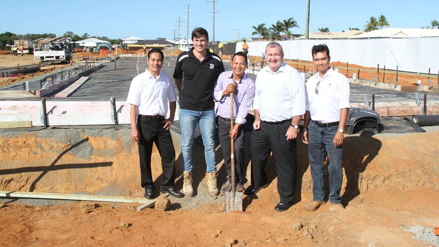 Bundaberg mayor Jack Dempsey and SSS Strawberries workers stand in a construction site with a shovel