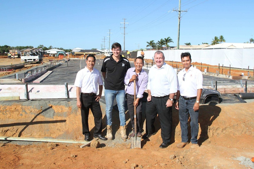 Bundaberg mayor Jack Dempsey and SSS Strawberries workers stand in a construction site with a shovel