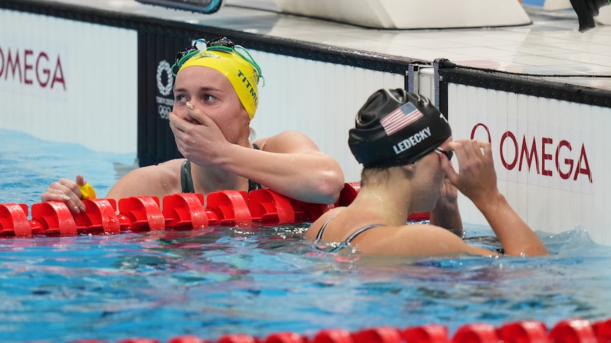 Swimmer with hand over her mouth in disbelief she won the race