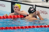 Swimmer with hand over her mouth in disbelief she won the race