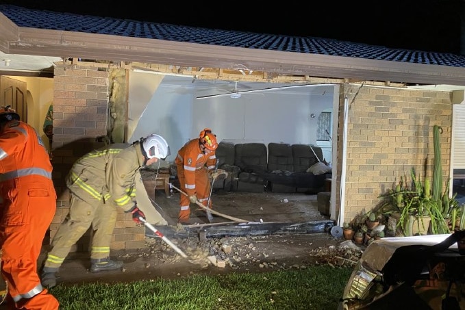 Emergency workers at a house damaged by a van.
