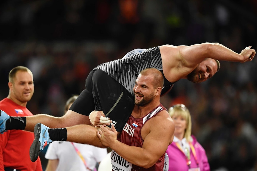 Tomas Walsh is lifted off the ground by Stipe Zunic after winning world championship gold.