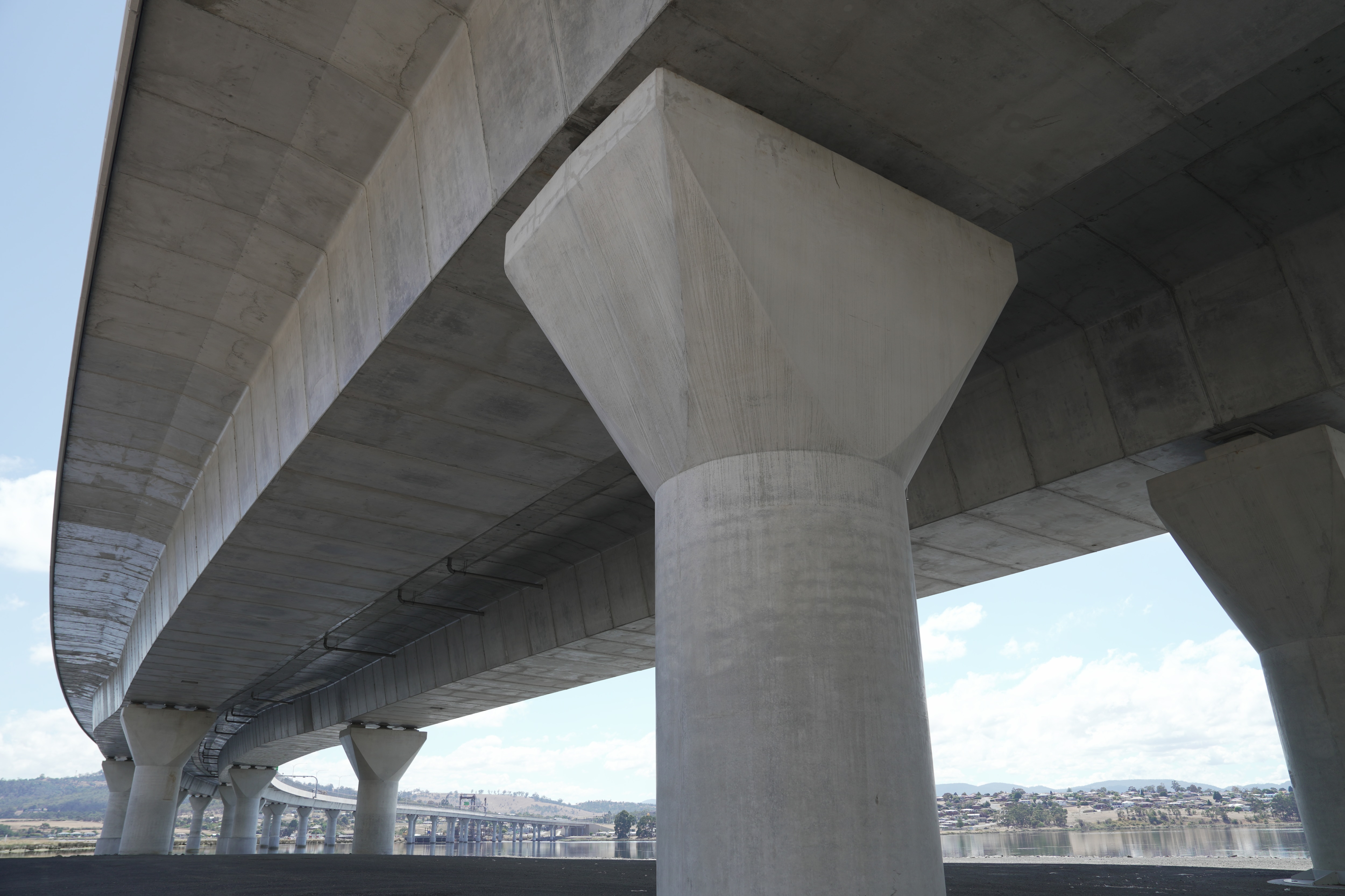 Imagem de uma grande ponte de concreto passando sobre um rio.