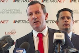 A head and shoulders shot of Mark McGowan speaking at a media conference in front of Ben Wyatt and a Metronet backdrop.