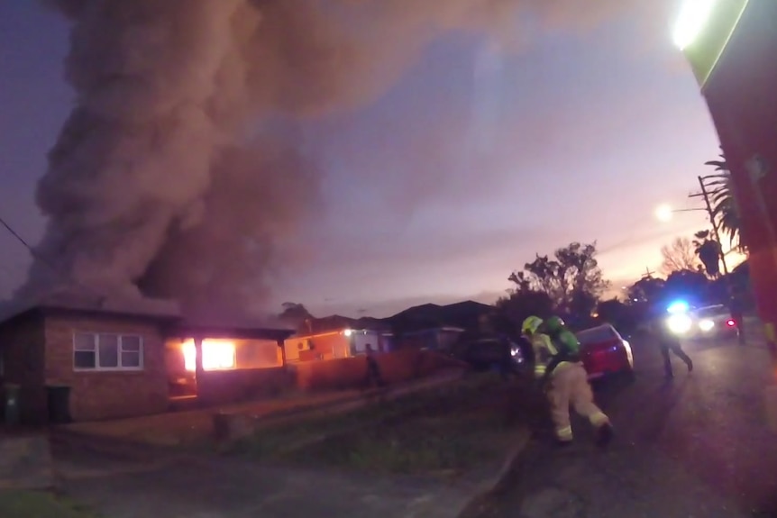 A house with fire billowing smoke