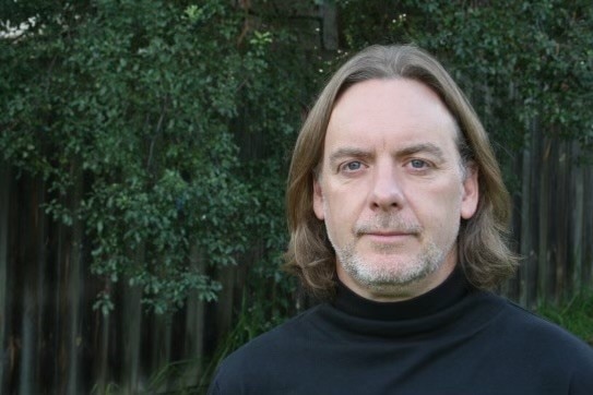 Portrait of a man standing in front of greenery   