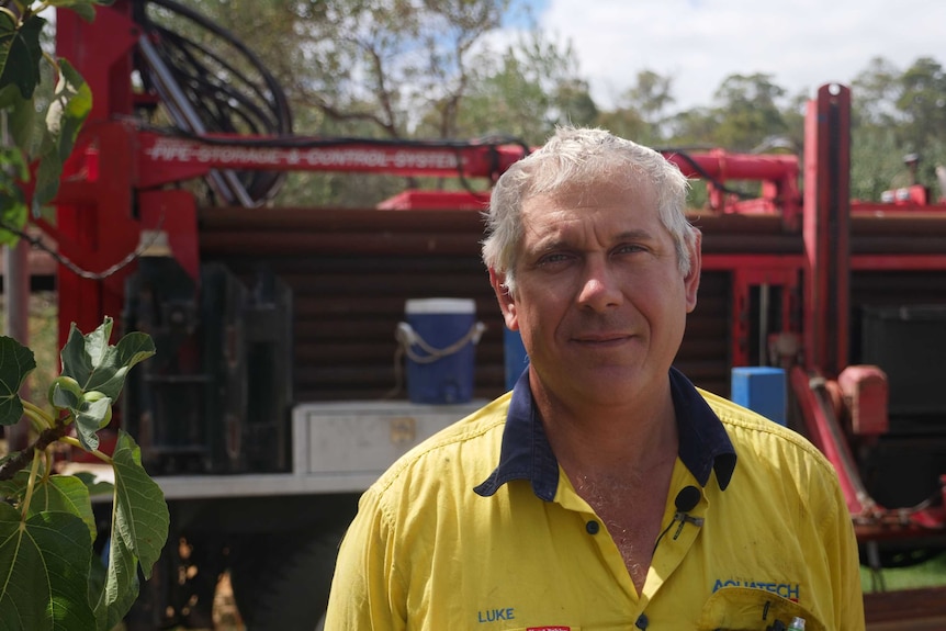 Water driller Luke Garbelini is standing in front of a drill rig