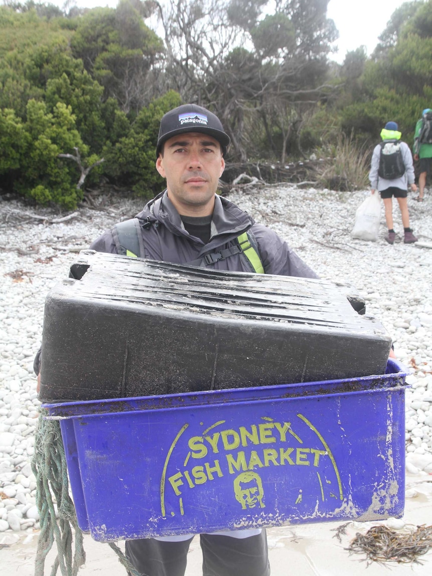 Joe Vukic holds a crate with the Sydney Fish Market logo