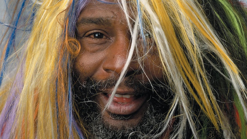 Close up photo of George Clinton's face. He has multicoloured hair.