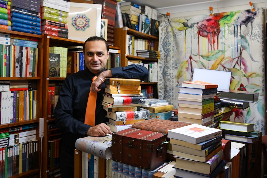 Mahdi Chavoshi leans on a stack of books