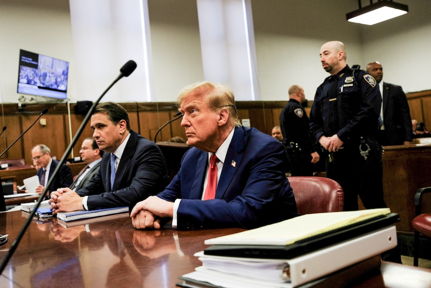 Donald Trump sits in court next to his lawyer Todd Blanche