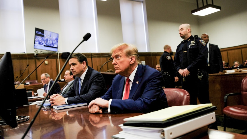 Donald Trump sits in court next to his lawyer Todd Blanche