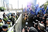 Protesters calling themselves patriots from the UPF and the True Blue Crew blocked by police at a gate in Melbourne.