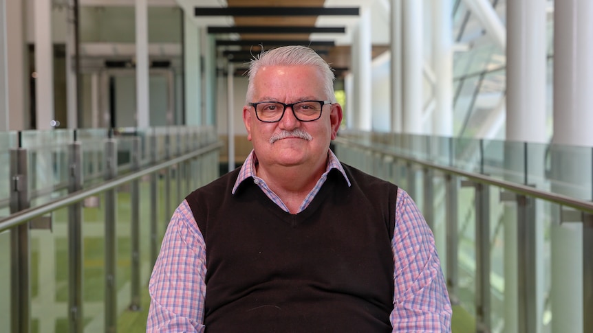 Transport Party leader and Eastern Metropolitan Region MP Rod Barton sits on a chair smiling at the camera.