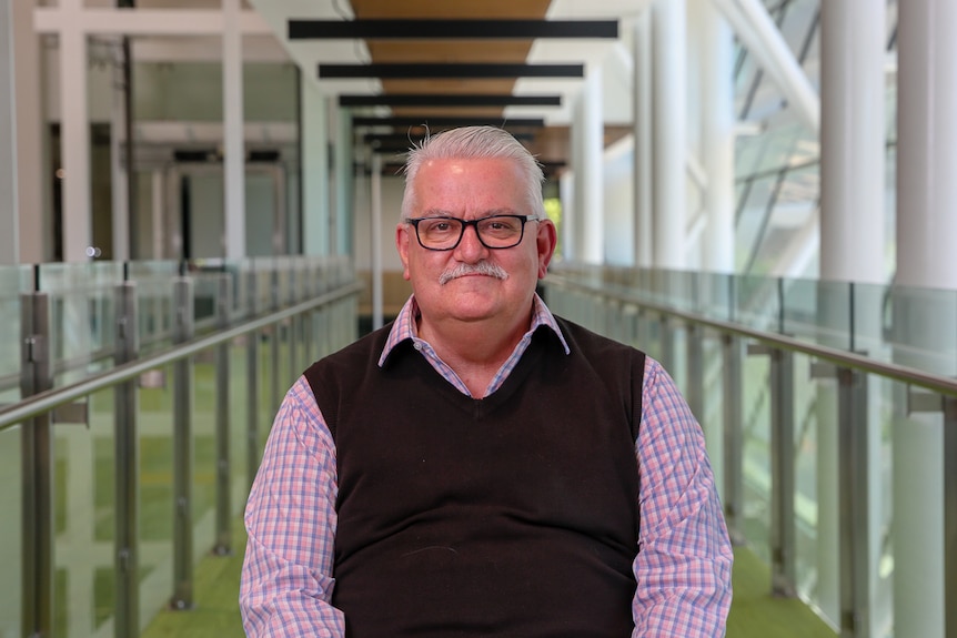 Transport Party leader and Eastern Metropolitan Region MP Rod Barton sits on a chair smiling at the camera.