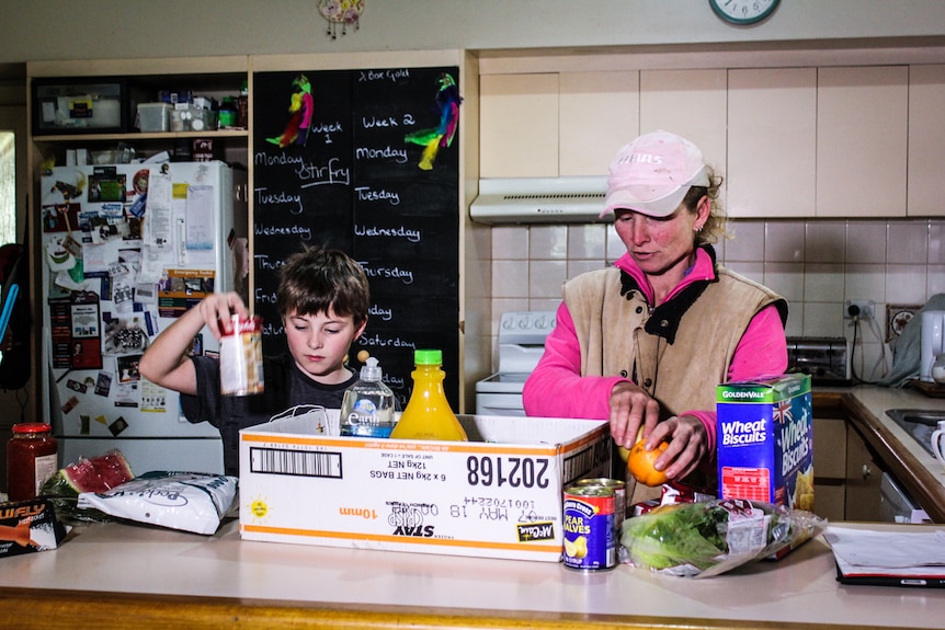 Farmer Janene Hall unpacks food with son Dylan