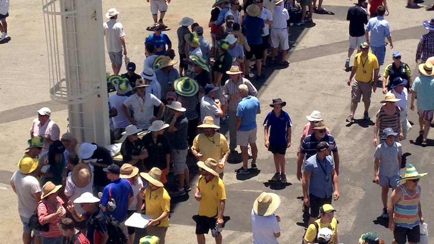 Spectators seek out shade under a scoreboard at the WACA ground.