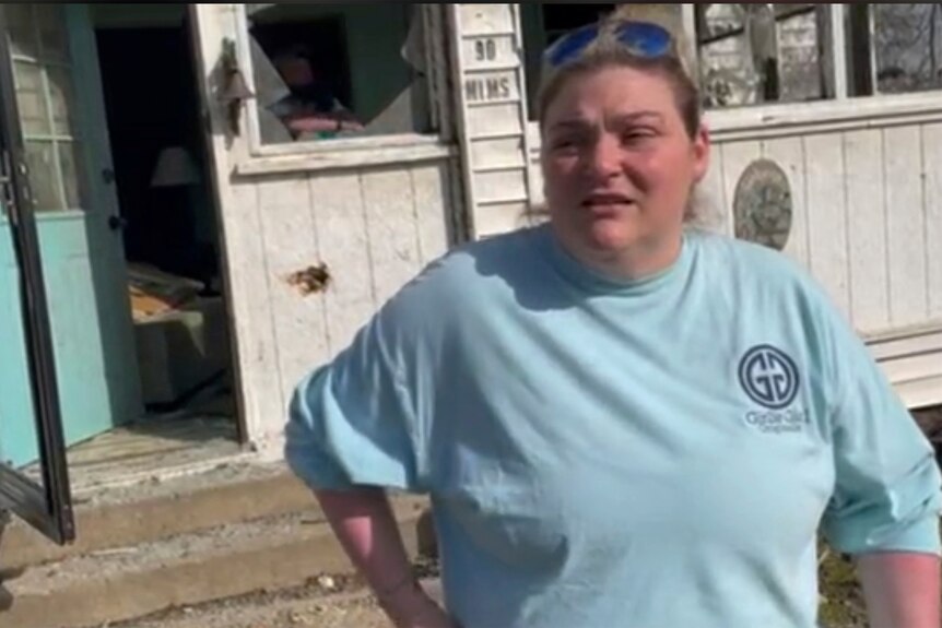 Christin George talks to news media outside a tornado damaged house in Silver City Mississippi
