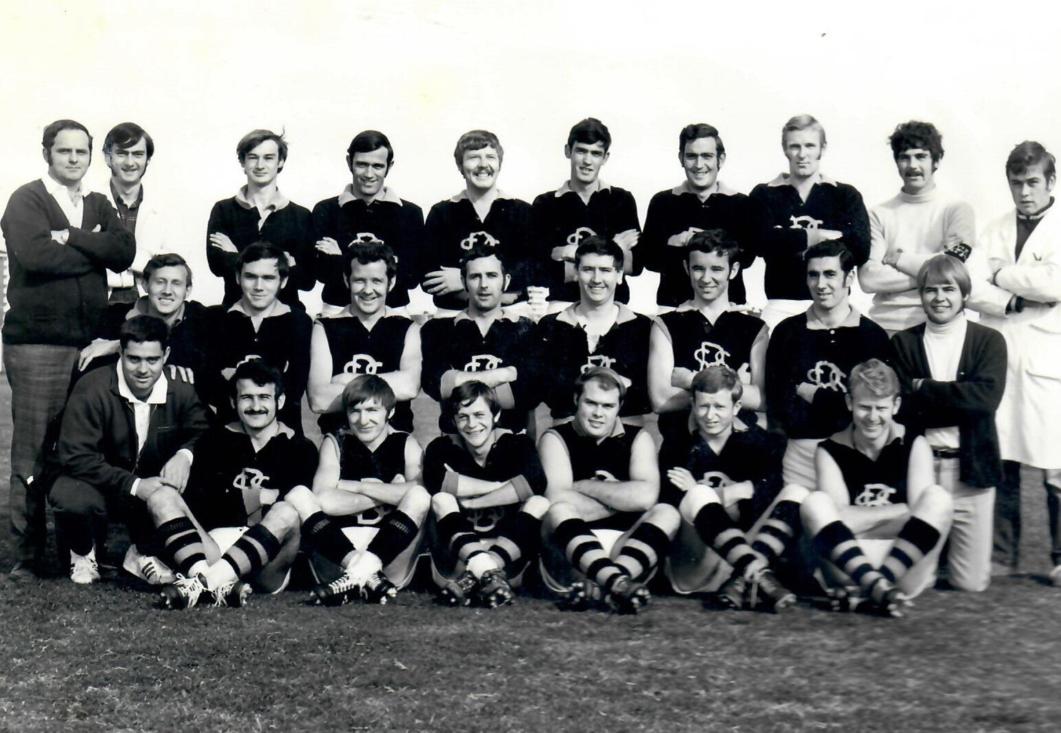 A black and white photo of suburban footballers posing for a team pic 
