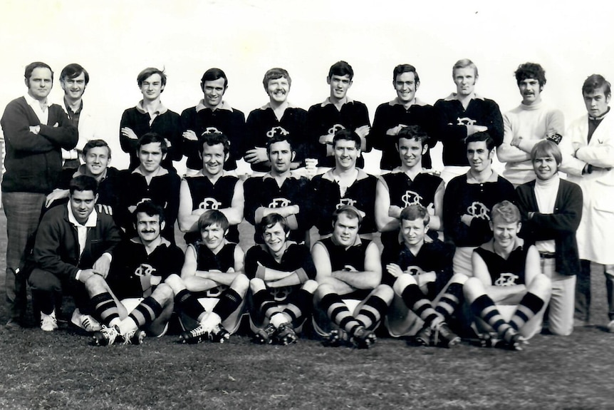 A black and white photo of suburban footballers posing for a team pic 