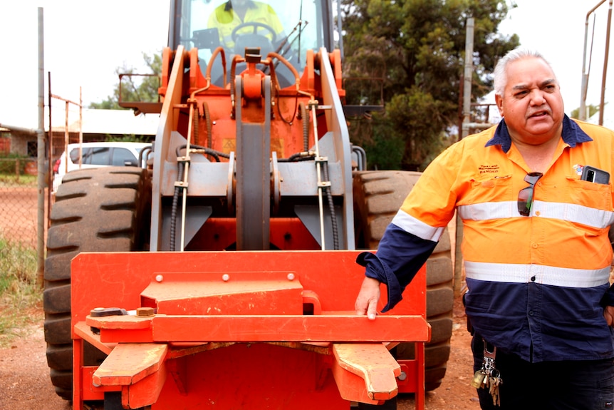 HM stands to the right of the machine, which looks like a tractor