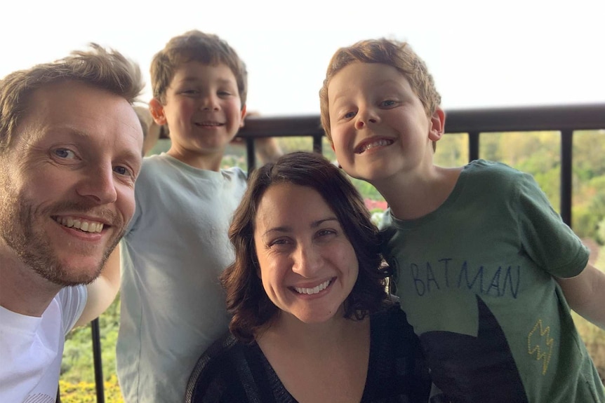 Simone McLaughlin with her husband and two children smiling to the camera