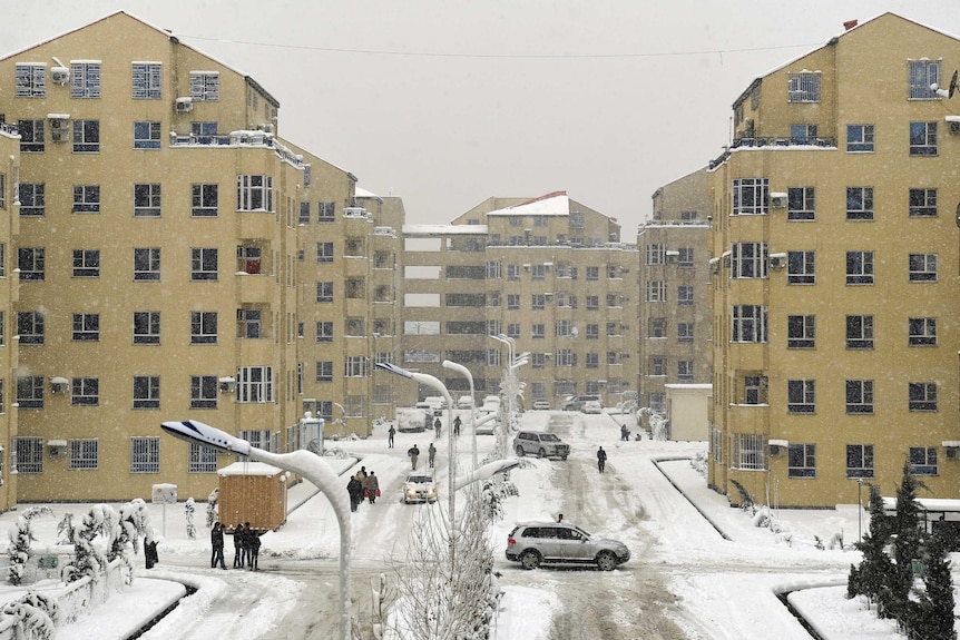 Residents drive through Kabul city centre where streets are covered in snow